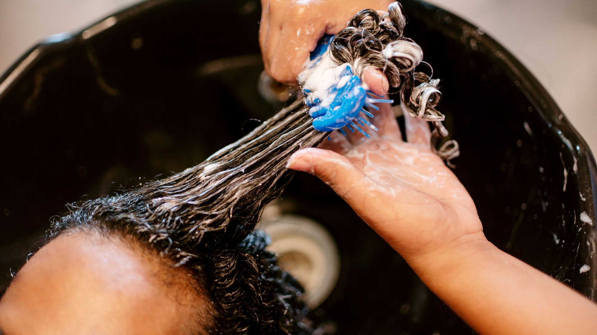 A close up of a person washing their hair