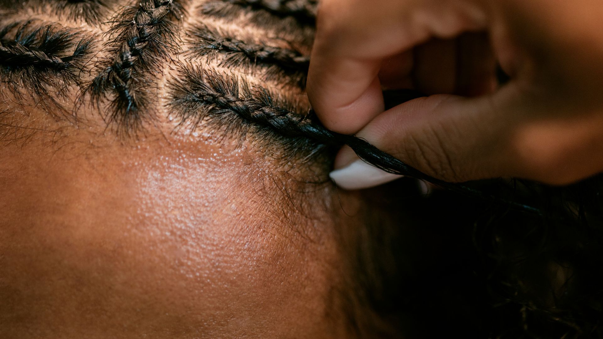 A woman is cutting her hair with scissors